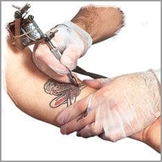 Tätowiernadel sticht Tattoo auf den Arm