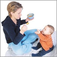 madre dando comida a bebé