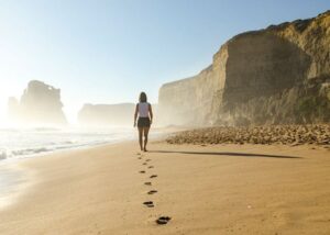 Frau läuft allein am Strand