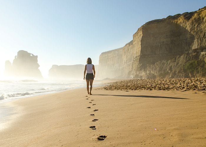 Frau läuft allein am Strand