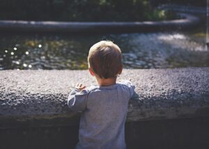 Kind schaut über eine Brücke